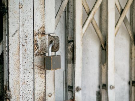 Old Padlock on the rusty iron sliding door. Close up with space for place your text.の写真素材