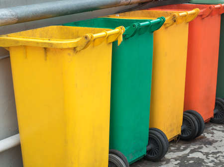 Different colored recycle garbage trash Bins at Sidewalk. Old Recycling Garbage for Environment.の写真素材