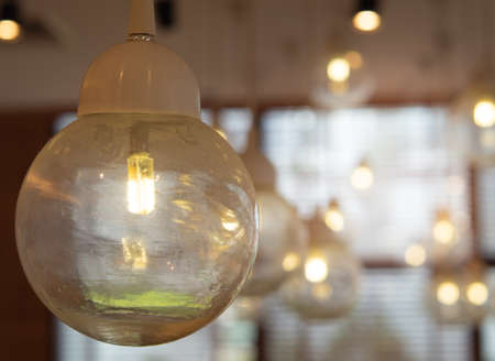 Glowing light bulb hanging from the ceiling restroom background. Interiors objects. With space for place your text.の写真素材
