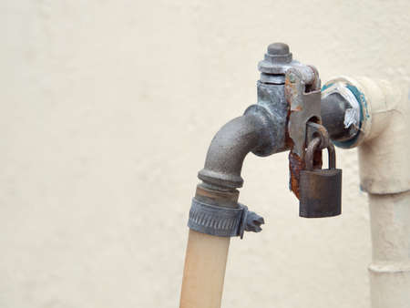 Rusted faucet locked with old bolt. With space for place your text.