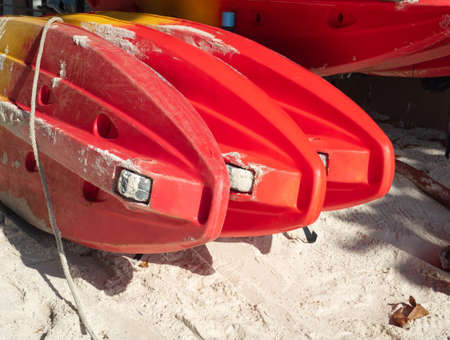 Red canoe or kayak boat are arranged ready to use on the beach.の写真素材