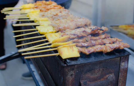 Barbecue pork or beef skewers are grilled over charcoal sold on street food.の写真素材
