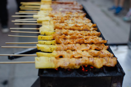 Barbecue pork or beef skewers are grilled over charcoal sold on street food.の写真素材