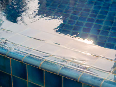 Water flowing from the edge of the swimming pool. Selective focus and close up image.
