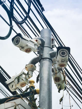 Old CCTV security camera on a high pole for public protection. Surveillance CCTV in the city.の写真素材