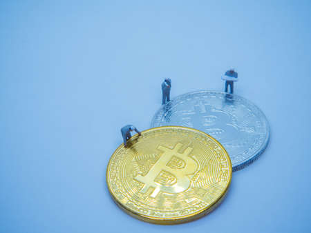 Miniature mechanic working on Golden coins of bitcoin cryptocurrency digital bit coin BTC currency...
