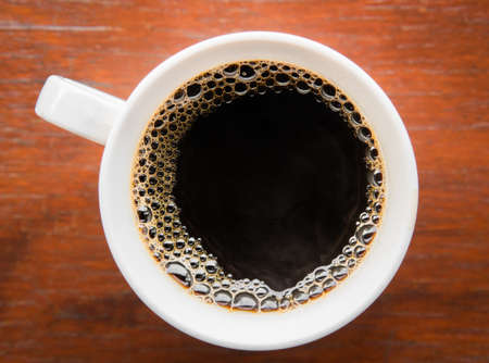Hot Americano coffee in a mug on a wooden board served at breakfast.の写真素材