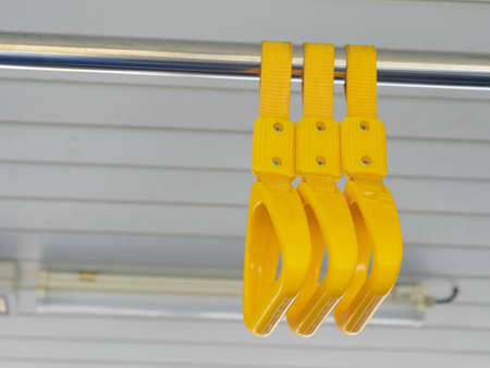 Yellow handrails for passengers on bus or trains.の写真素材