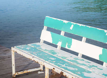 Old wooden benches placed along the pier for relaxation.の写真素材