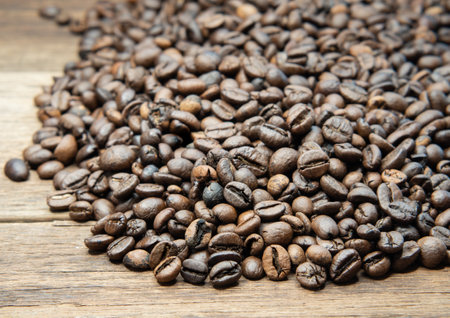 Roasted coffee beans arranged on a wooden floor.の写真素材