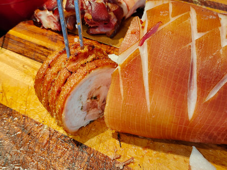 Crispy roasted porchetta served on a wooden cutting board.の写真素材