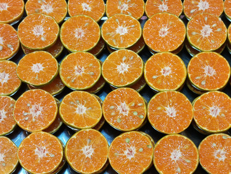 Fresh oranges halved and arranged in a row.