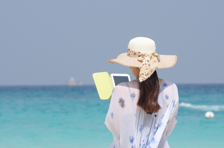 women taking photo by tablet at the seaの写真素材