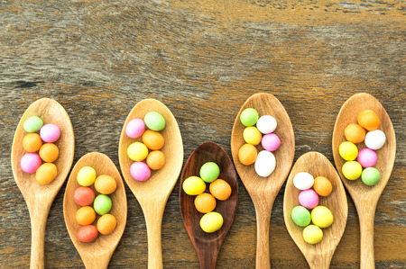 Colourful candy on wooden spoonの写真素材