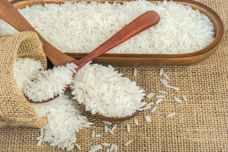 Jasmine rice with wooden spoon on textileの写真素材