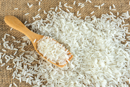 Jasmine rice with wooden spoon on textile backgroundの写真素材