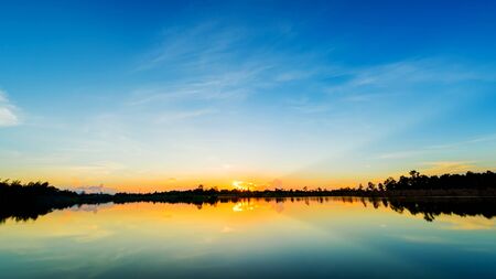 Sunset at the calm lake with blue skyの写真素材
