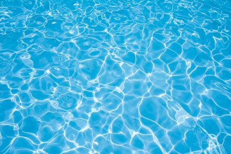 Beautiful gentle wave in swimming pool with sun reflectionの写真素材