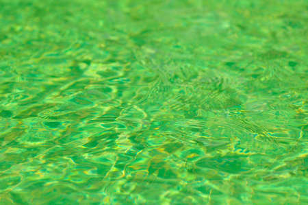 Green water surface with sun reflection in swimming poolの写真素材