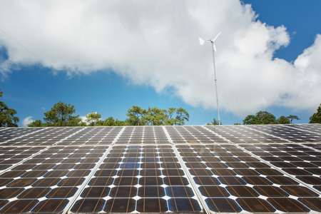 Solar panels with blue sky and wind turbine