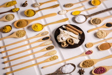 Various ingredient in container for cooking flat lay on plank, Different herbal and spice in wooden scoop on the tableの写真素材