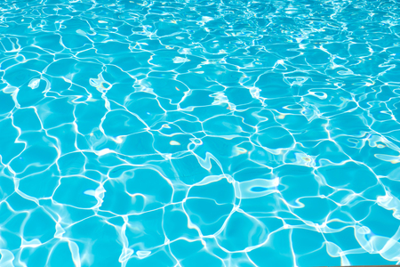 Blue and bright water surface and ripple wave in swimming poolの写真素材