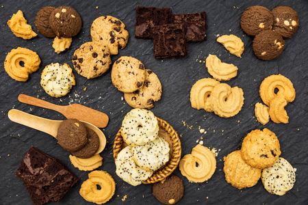 Top view different cookies on table top, Flat lay of various cookies on black stone for background, Prepared cookies food buffet on table for serveの写真素材