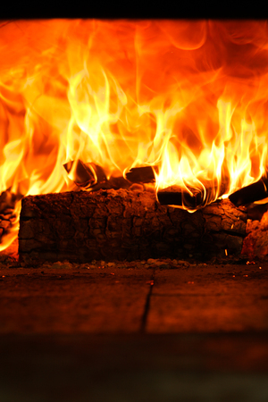 A fire in full blaze inside an oven.の写真素材