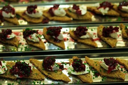 Crutons topped with cheese and jam on trays ready to be passed around and eaten.の写真素材
