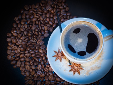 A cup and coffe grains on backgroundの写真素材