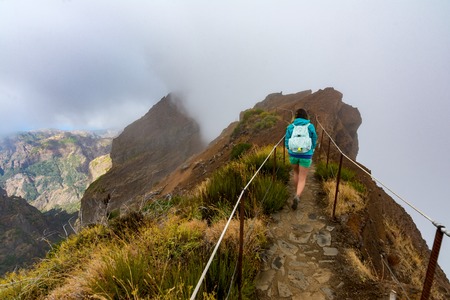 Woman traveler at Madeira mountain path between Pico Ruivo and Pico Areeiroの写真素材
