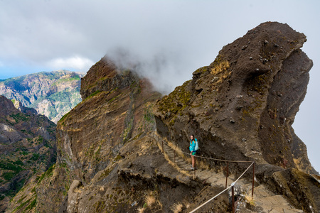 Woman traveler at Madeira mountain path between Pico Ruivo and Pico Areeiroの写真素材