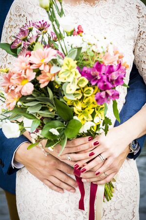 Embrace the newlyweds and wedding flowerの写真素材
