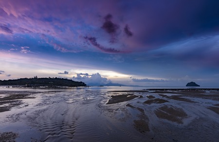 Purple colorful sunset with Halloween face on the beachの写真素材