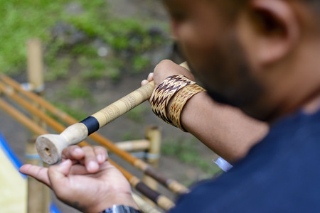 Man showing tourist where to insert poisoned stick into blowpipeの写真素材