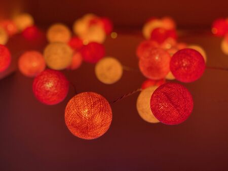 Red light ball decorations hanging in a soft ambient evening settingの写真素材