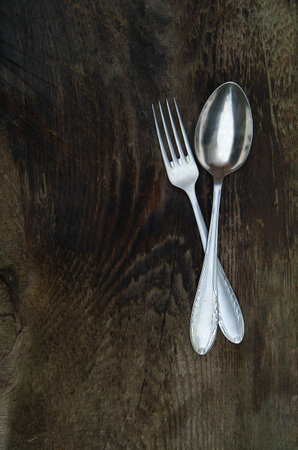 Old fork and spoon on wooden backgroundの写真素材