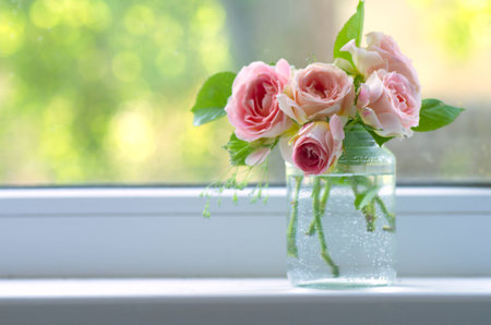 Bouquet of flowers pink roses on the window. Rustic still life. Cosiness in the house.の写真素材