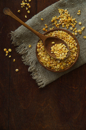 Dried peas and spoon on old wooden table. Health and diet concept.