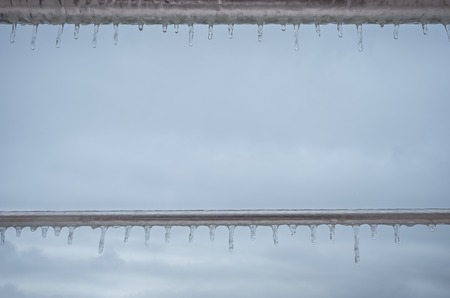 Frozen drops of water on a metal fenceの写真素材