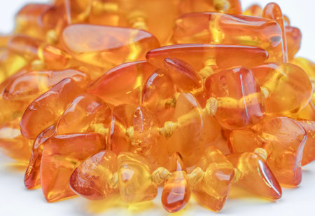 Macro of amber necklaces wrapped in a circle on a white backgroundの写真素材