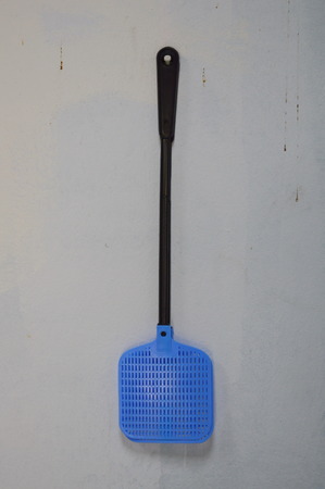 fly swatter hanging on the wallの写真素材