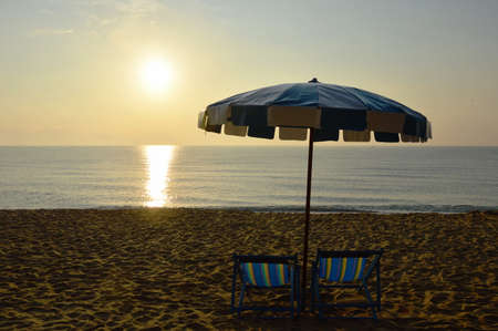 beach canvas beds with blue and white umbrellaの写真素材