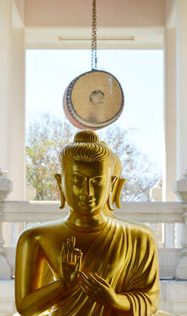 golden Buddha and big drum in a Buddhist templeの写真素材