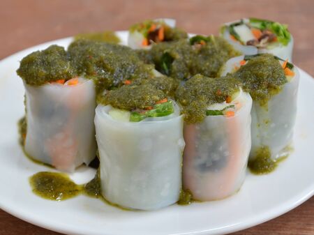 spicy sauce dressing on Thai fresh spring roll with herbs