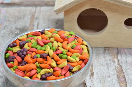 bird food on stainless bowl and little houseの写真素材