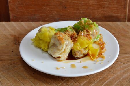 Chinese steamed dumpling dressing soy sauce on dishの写真素材