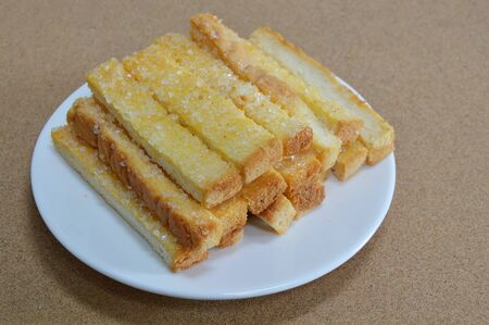 butter toasted bread topping sugar on dishの写真素材