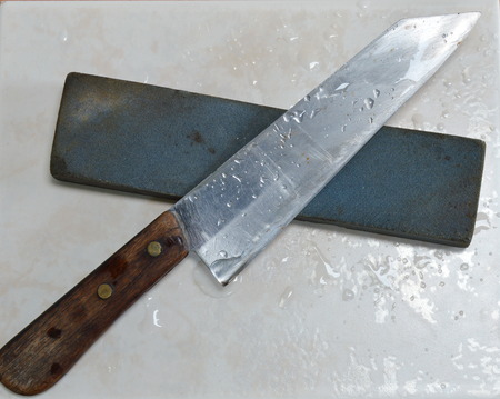 knife and whetstone on tile floor