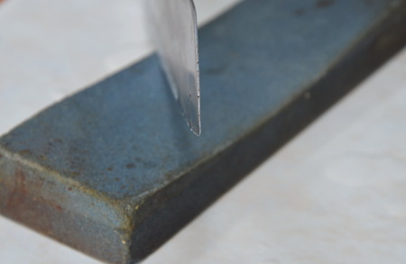 kitchen knife blade on whetstone